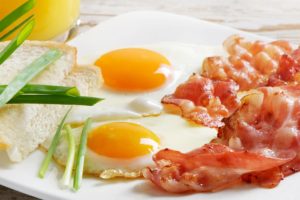 Deliciosos huevos con bacon y tomate, perfectos para el desayuno o la cena.